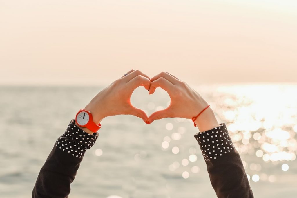 deux mains formant un coeur devant la mer