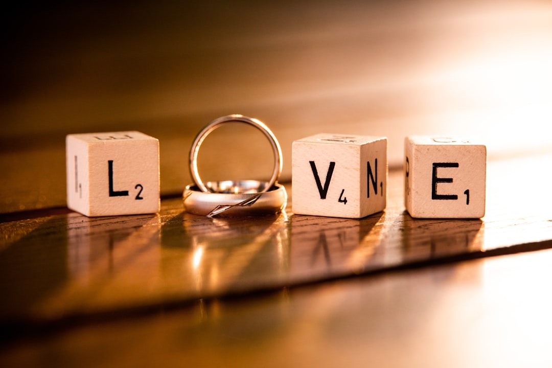 sur une table des dés avec un L une alliance pour le O, un dés en V et un autre Dés en E, le mot LOVE