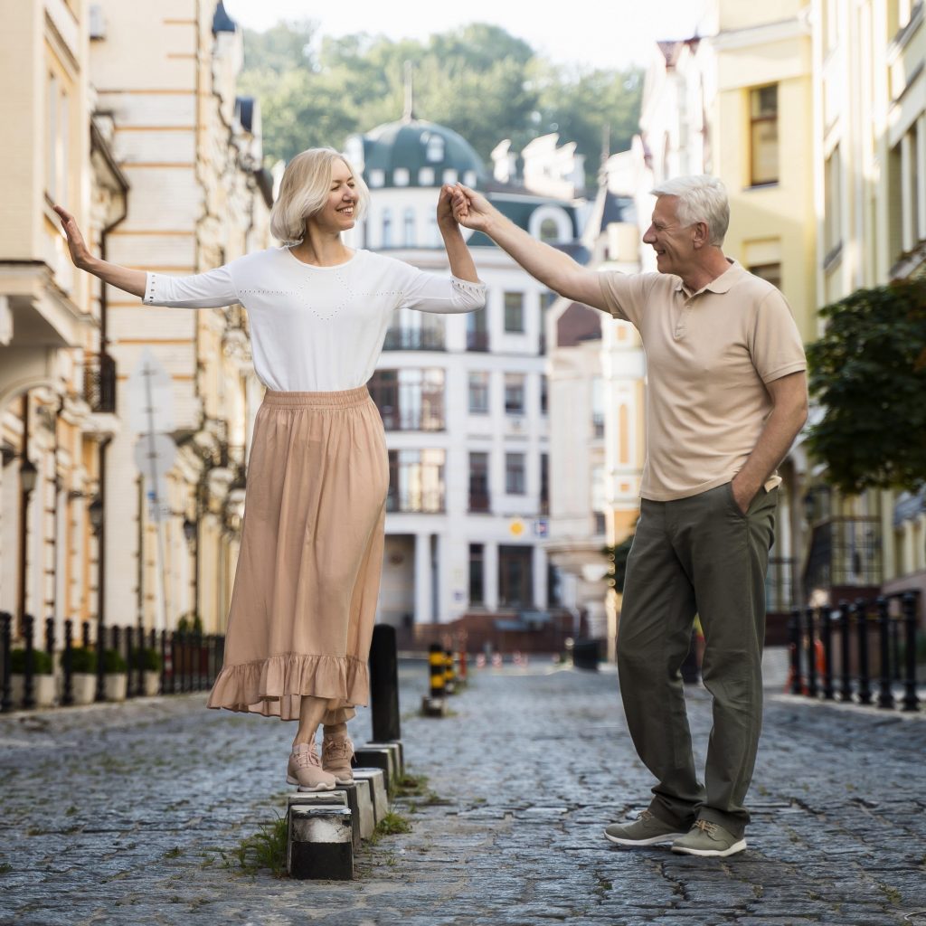 couple sénior en ville l'homme tiens la main de la femme qui marche sur des obstacles
