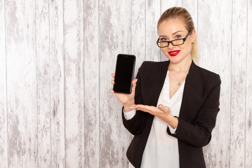 Femme élégante tenant un téléphone entre les mains