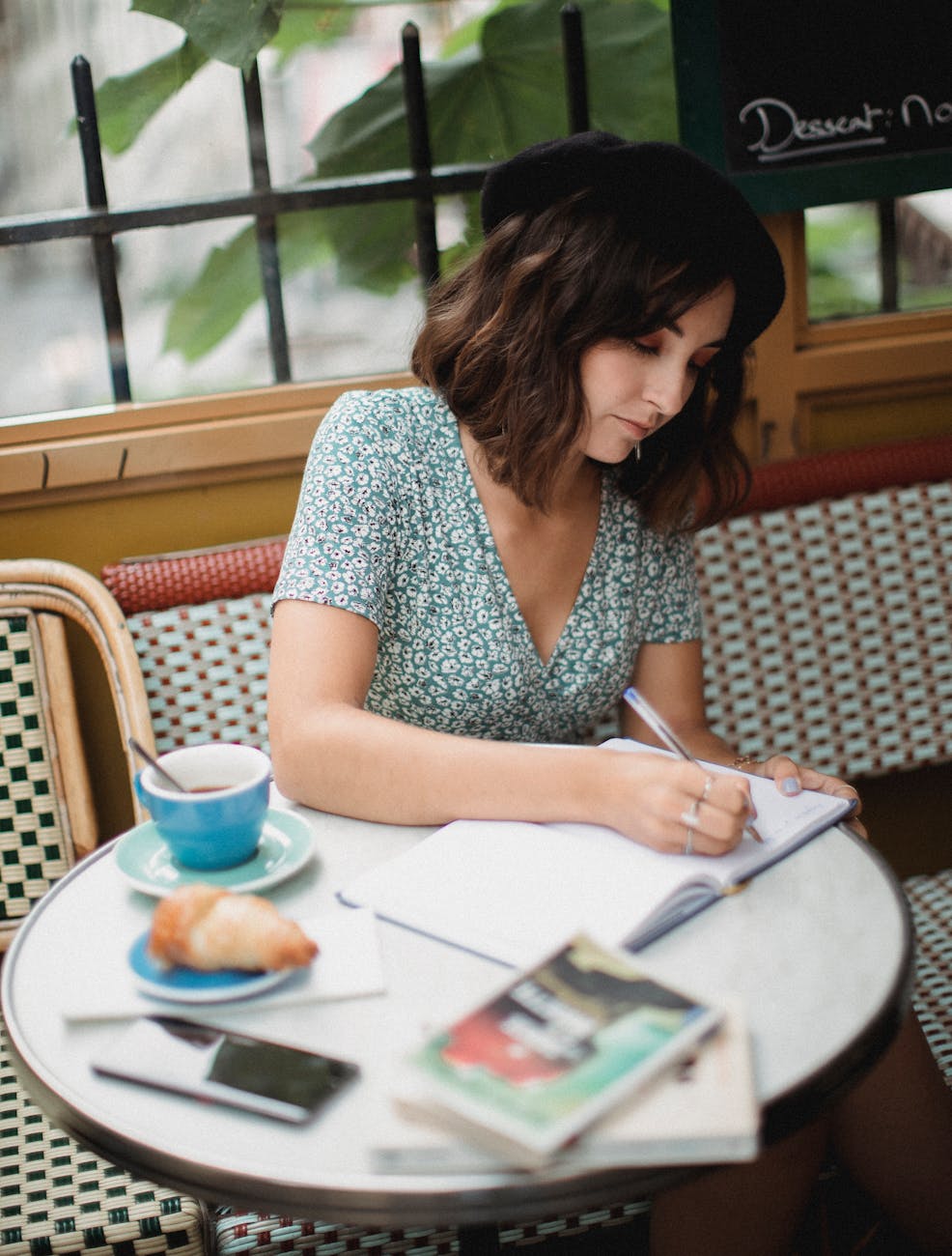 woman in blue and white dress writing on a notebook